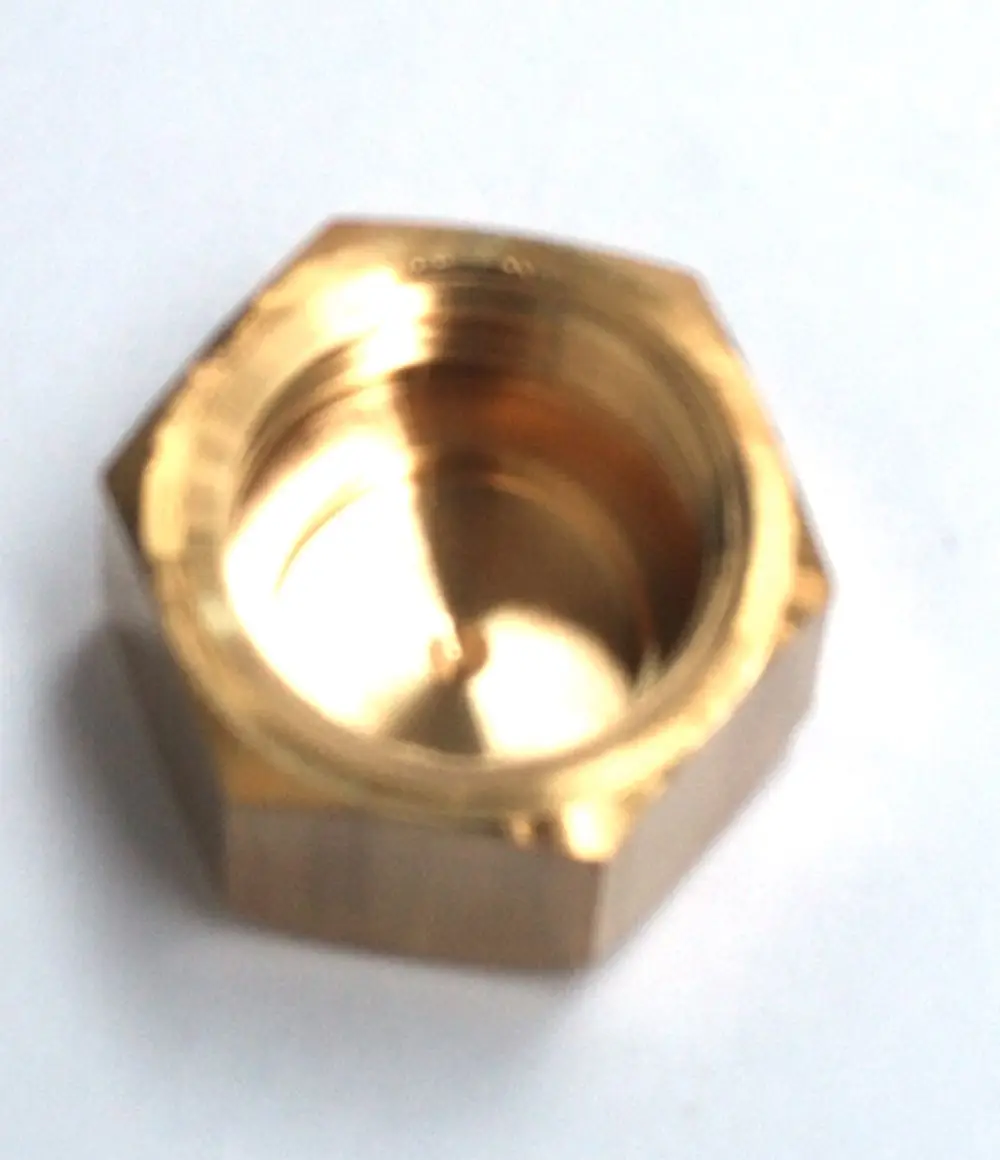 Brass valve cap von Daikin, mit sechseckiger Form und innerer Gewindebohrung, auf hellem Hintergrund abgebildet.